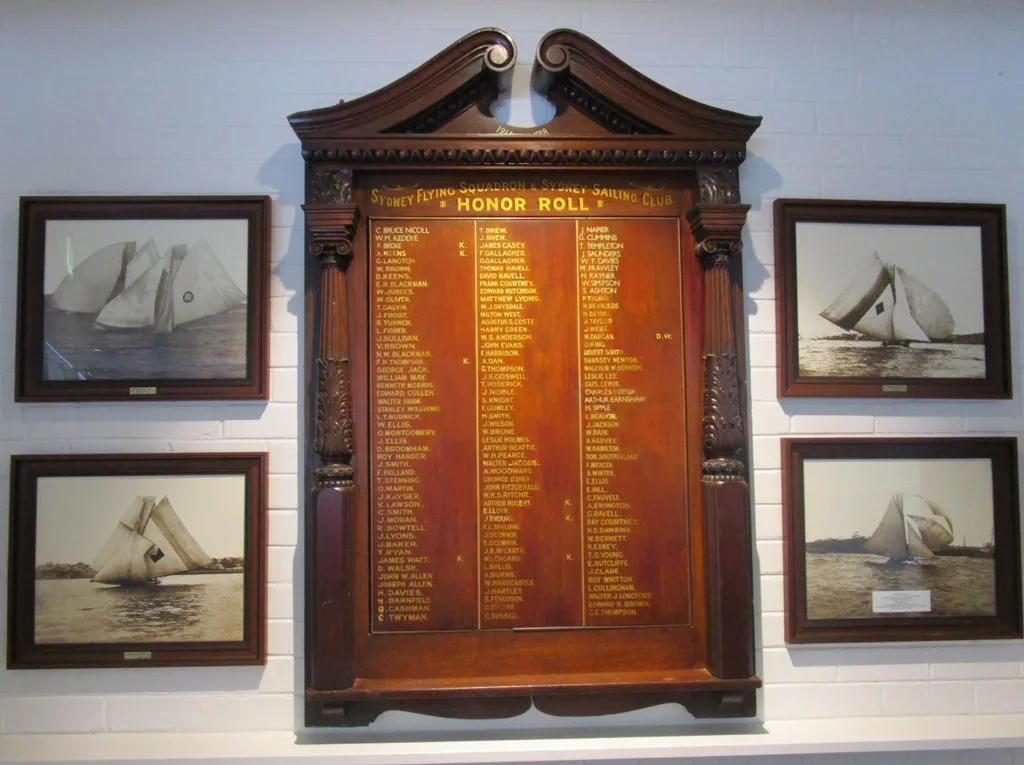 The mahogany and gilt Honor Roll board flanked by framed sepia skiff photographs on the clubhouse wall